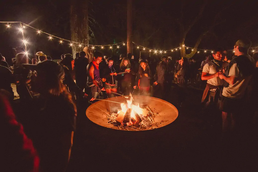 Group gathered around a campfire under the stars at summer camp
